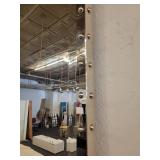 A Silver Framed Beveled Mirror with Rivet Accents.