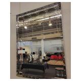 A Silver Framed Beveled Mirror with Rivet Accents.