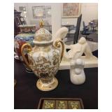 A table full of decor items, animal figures, pottery, glassware, bookends, candle holders, dolls etc.