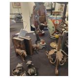 A table full of decor items, animal figures, pottery, glassware, bookends, candle holders, dolls etc.