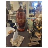 A table full of decor items, animal figures, pottery, glassware, bookends, candle holders, dolls etc.