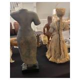 A table full of decor items, animal figures, pottery, glassware, bookends, candle holders, dolls etc.