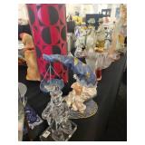 A table full of Figurines, Dolls, Glassware, Leaded Glass Sconce Cover, China, Perfumes etc.