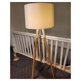 A Tripod Floor Lamp with wood legs.