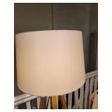 A Tripod Floor Lamp with wood legs.