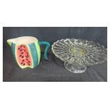 Kitchen Decor Lot with Watermelon Pitcher, Glass Cake Stand, and 2 Jeanne Down Collector Plates