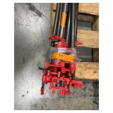 Black pipe bars, various lengths with red pipe clamps that have swing handles