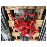 Black pipe bars with red pipe clamps that have swing handles