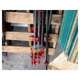 Black pipe bars with red pipe clamps that have swing handles