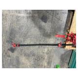 Black pipe bars with red pipe clamps that have swing handles