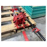 Black pipe bars with red pipe clamps that have swing handles