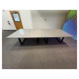 Conference table with four U-shaped metal leg supports.