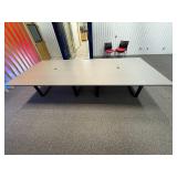 Conference table with four U-shaped metal leg supports.