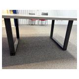 Conference table with four U-shaped metal leg supports.