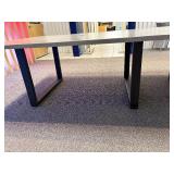 Conference table with four U-shaped metal leg supports.