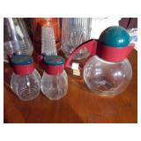 The image features a collection of vintage kitchenware, including several glass salt and pepper shakers and a vintage thermos bottle.