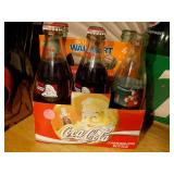 several bottles of 7UP soda in a vintage-style green cardboard carrier.