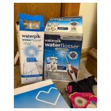Group of Waterpik Water Flossers, CVS Digital Body Scale, Cosmetic Bags, and Accessories