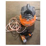 RIDGID 6 Gal. 150 PSI Portable Electric Oil-Free Jobsite Pancake Air Compressor with 25 ft. Air Hose and 18GA Brad Nailer Good Used Customer Returns See Pictures