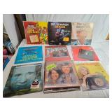 Variety of vinyl records featuring notable country and pop artists such as Sam & Kirk McGee, Del Shannon, Carl Smith, Mel Tillis, Marty Robbins, The Carpenters, Johnny Duncan, Mickey Gilley, Charlie R