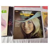 Variety of vinyl records featuring notable country and pop artists such as Sam & Kirk McGee, Del Shannon, Carl Smith, Mel Tillis, Marty Robbins, The Carpenters, Johnny Duncan, Mickey Gilley, Charlie R