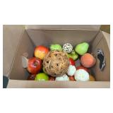 Box of decorative fruit, woven balls, and other dcor