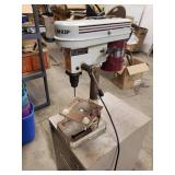 Tool shop drill press mounted to a metal cabinet