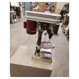 Tool shop drill press mounted to a metal cabinet