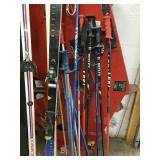 Lots of snow skis, poles down hill and cross country
