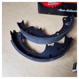 Automotive Parts Collection including BrakeBest Brake Shoes, Motorcraft Spark Plugs (SP-486), and NAPA Thermostat, Halogen headlamp (type HB1 9004).