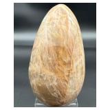 A graceful Peach Moonstone freeform, glowing with soft, warm hues of apricot and cream and flashes in the sunlight.