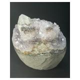 A stunning Amethyst crystal perched on its natural matrix, featuring delicate Calcite inclusions that add depth and character.