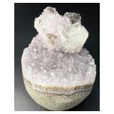 A stunning Amethyst crystal perched on its natural matrix, featuring delicate Calcite inclusions that add depth and character.