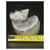 A stunning Amethyst crystal perched on its natural matrix, featuring delicate Calcite inclusions that add depth and character.