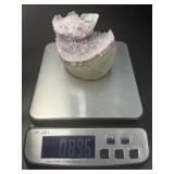 A stunning Amethyst crystal perched on its natural matrix, featuring delicate Calcite inclusions that add depth and character.