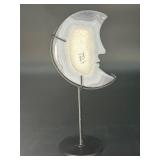 A luminous Botswana Agate druzy carved into a moon shape, showcasing delicate bands of soft gray, caramel, and cream. The sparkling druzy surface catches the light, in a custom metal stand.