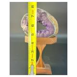 A mesmerizing deep amethyst portal, showcasing rich violet crystals that form a natural, glowing window into the stone’s heart. On a custom wooden stand.