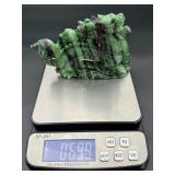 A striking hand-carved dragon sculpted from natural ruby zoisite, showcasing vibrant green and deep red tones.