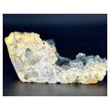 A striking specimen of large blue fluorite perched atop a clear quartz crystal matrix.