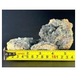 A striking specimen of large blue fluorite perched atop a clear quartz crystal matrix.