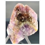 A vibrant Super 7 slice showcasing the unique combination of seven powerful minerals—amethyst, cacoxenite, goethite, lepidocrocite, rutile, smoky quartz, and clear quartz.