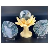 A serene moss agate collection featuring two hand-carved leaf-shaped pieces and a polished sphere with a druzy center resting on a lotus stand.