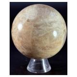 Moonstone Sphere with Blue Flashes is a captivating crystal sphere known for its soft, luminous glow and stunning blue flashes that shimmer as the light moves across its surface.