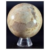 Moonstone Sphere with Blue Flashes is a captivating crystal sphere known for its soft, luminous glow and stunning blue flashes that shimmer as the light moves across its surface.