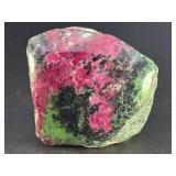Ruby Zoisite is a striking natural stone that beautifully blends vibrant ruby inclusions with earthy green zoisite, often accented by dark hornblende veins.