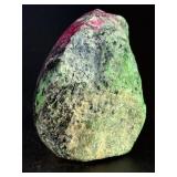 Ruby Zoisite is a striking natural stone that beautifully blends vibrant ruby inclusions with earthy green zoisite, often accented by dark hornblende veins.