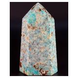 Amazonite Tower is a beautifully polished crystal tower that showcases the soothing, turquoise-green hues of amazonite, often accented with natural striations and subtle white veining.