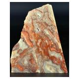 Crazy Lace Agate is a vibrant and eye-catching crystal known for its intricate, swirling patterns and lively mix of colors, typically including creamy whites, warm reds, oranges, and browns.