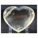 Natural Clear Quartz Puffy Heart with inclusions is a charming, hand-polished crystal carved into a soft, rounded heart shape.