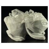 Hand-Carved Quartz Frog Cluster is a charming and energetically vibrant crystal piece, expertly carved into the shape of a frog while preserving the natural beauty of the quartz cluster.